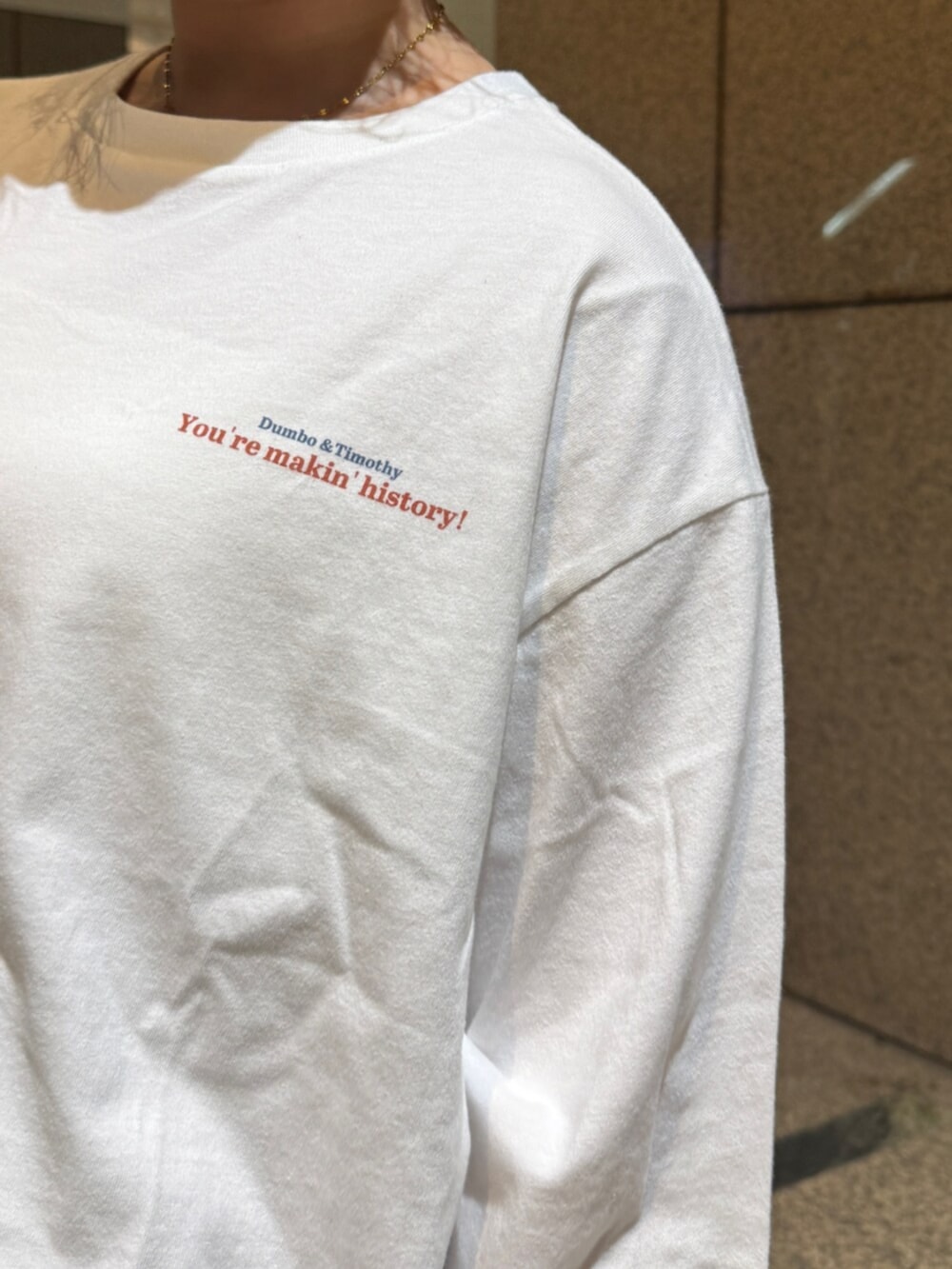 ホワイト系のTシャツ/カットソー、シルバー系のハンドバッグ、グレー系のスウェットパンツを着用したレディースの冬コーディネートの5枚目の写真