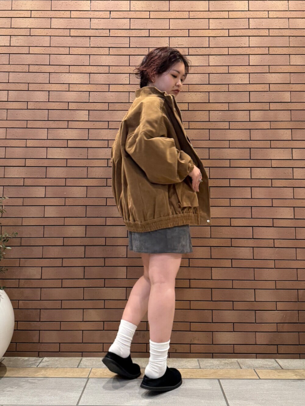 ブラック系のスリッポン、グレー系のTシャツ/カットソー、ブラウン系のブルゾンを着用したレディースの秋コーディネートの5枚目の写真