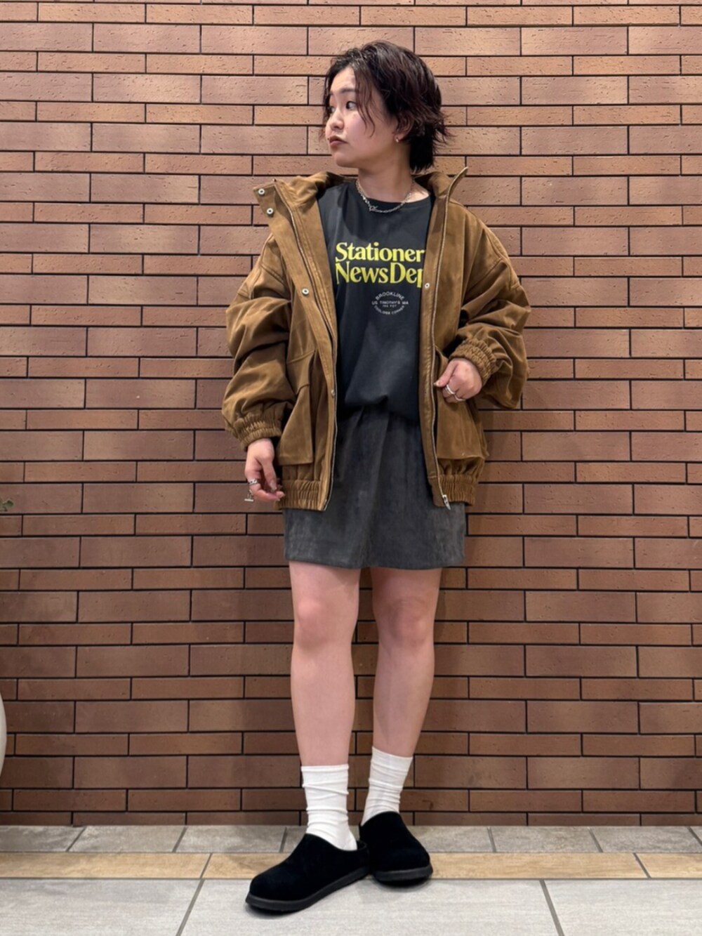 ブラック系のスリッポン、グレー系のTシャツ/カットソー、ブラウン系のブルゾンを着用したレディースの秋コーディネートの2枚目の写真