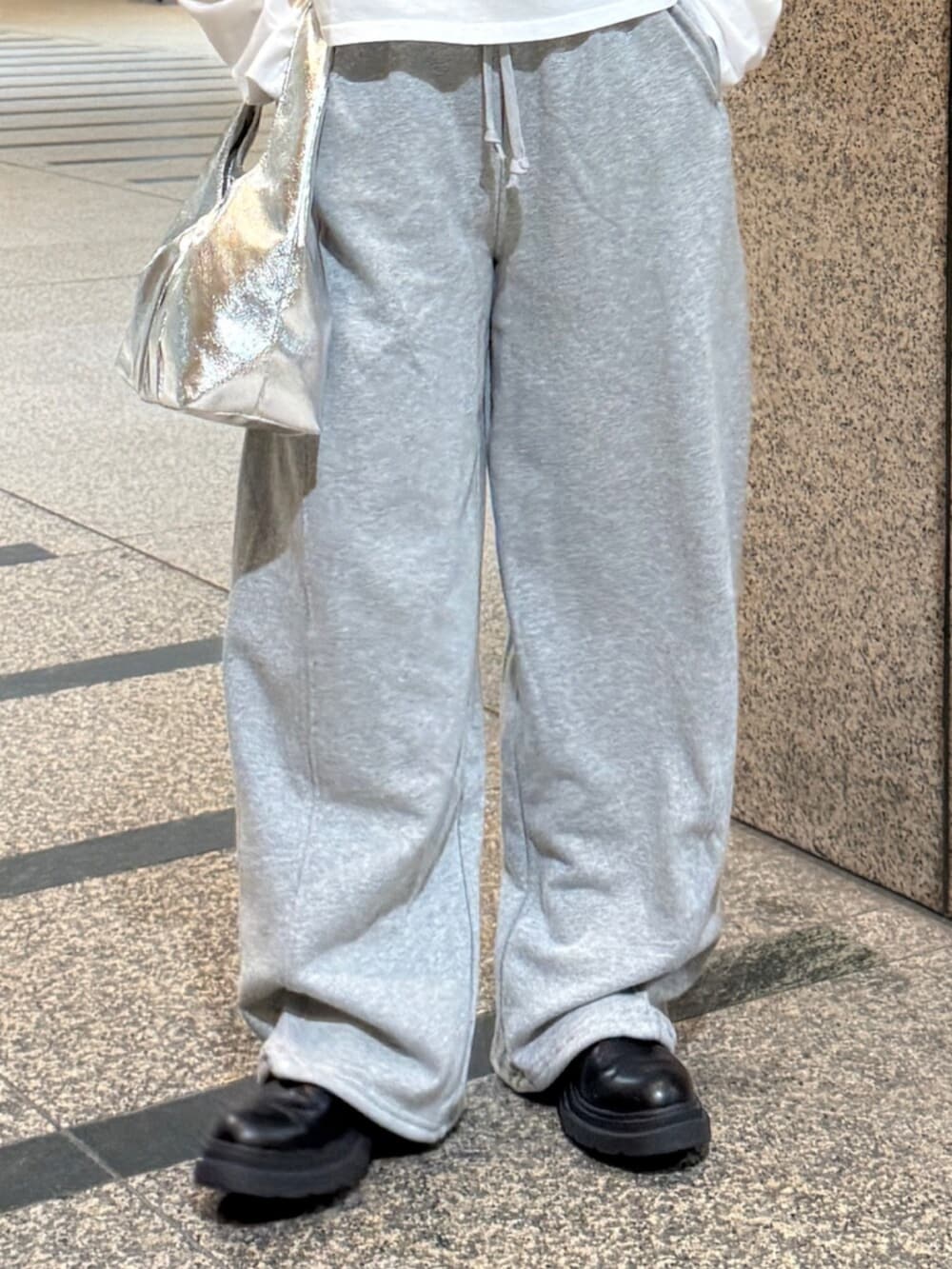 ホワイト系のTシャツ/カットソー、シルバー系のハンドバッグ、グレー系のスウェットパンツを着用したレディースの冬コーディネートの7枚目の写真