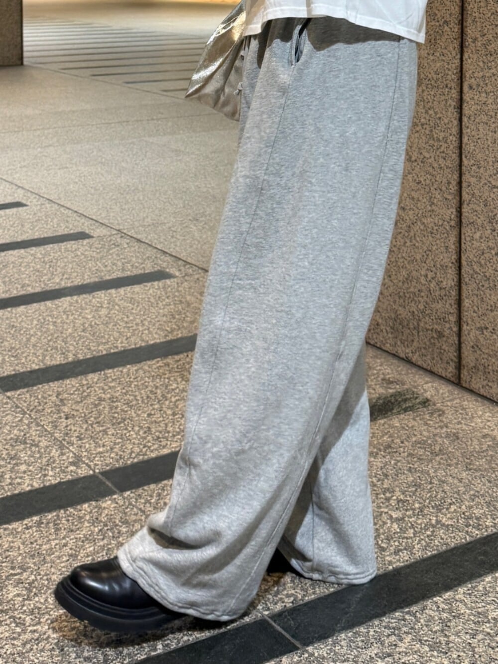 ホワイト系のTシャツ/カットソー、シルバー系のハンドバッグ、グレー系のスウェットパンツを着用したレディースの冬コーディネートの8枚目の写真