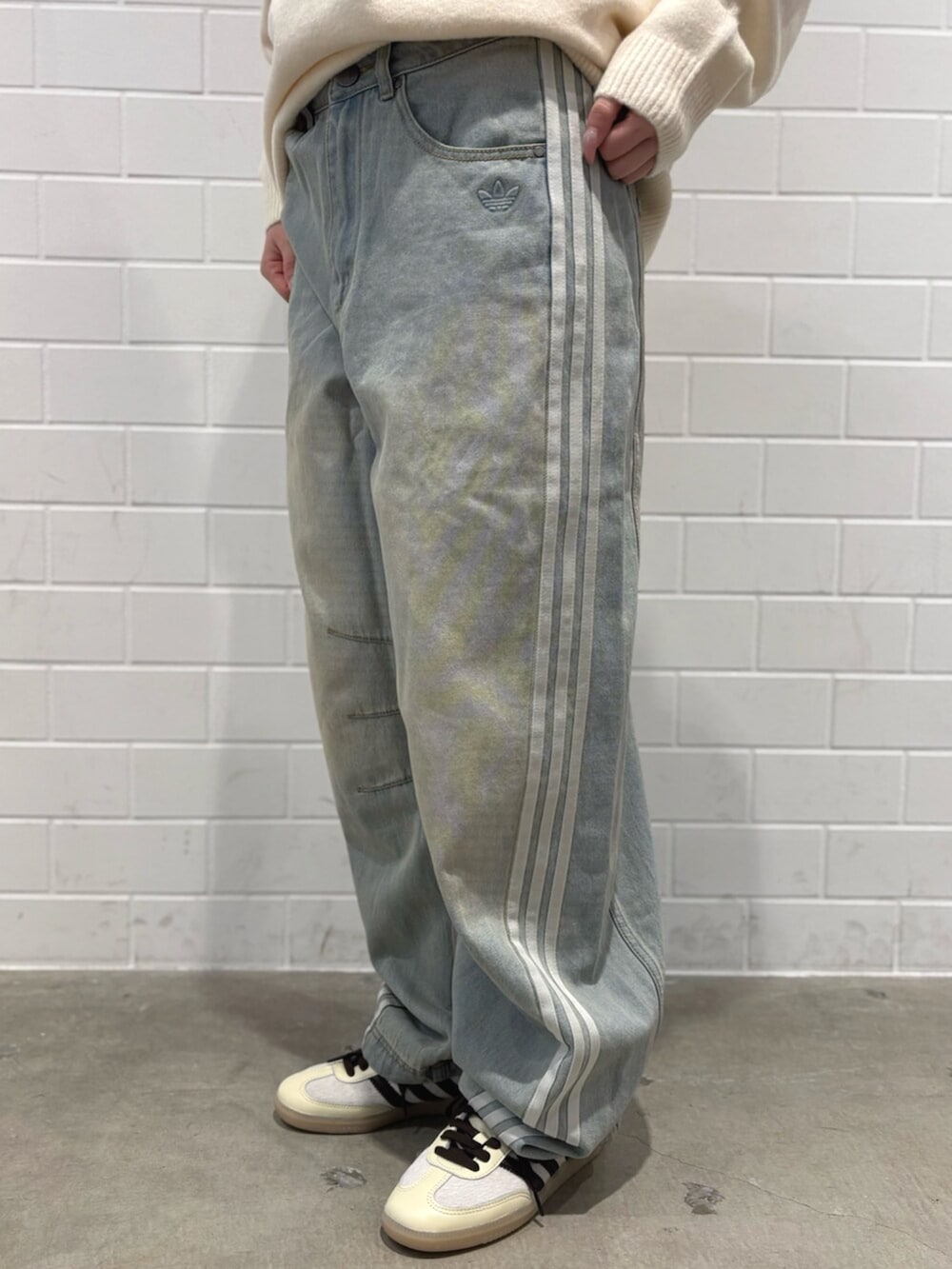 ブルー系のデニムパンツ、ホワイト系のニット/セーター、ブラウン系のバッグを着用したレディースの秋コーディネートの6枚目の写真