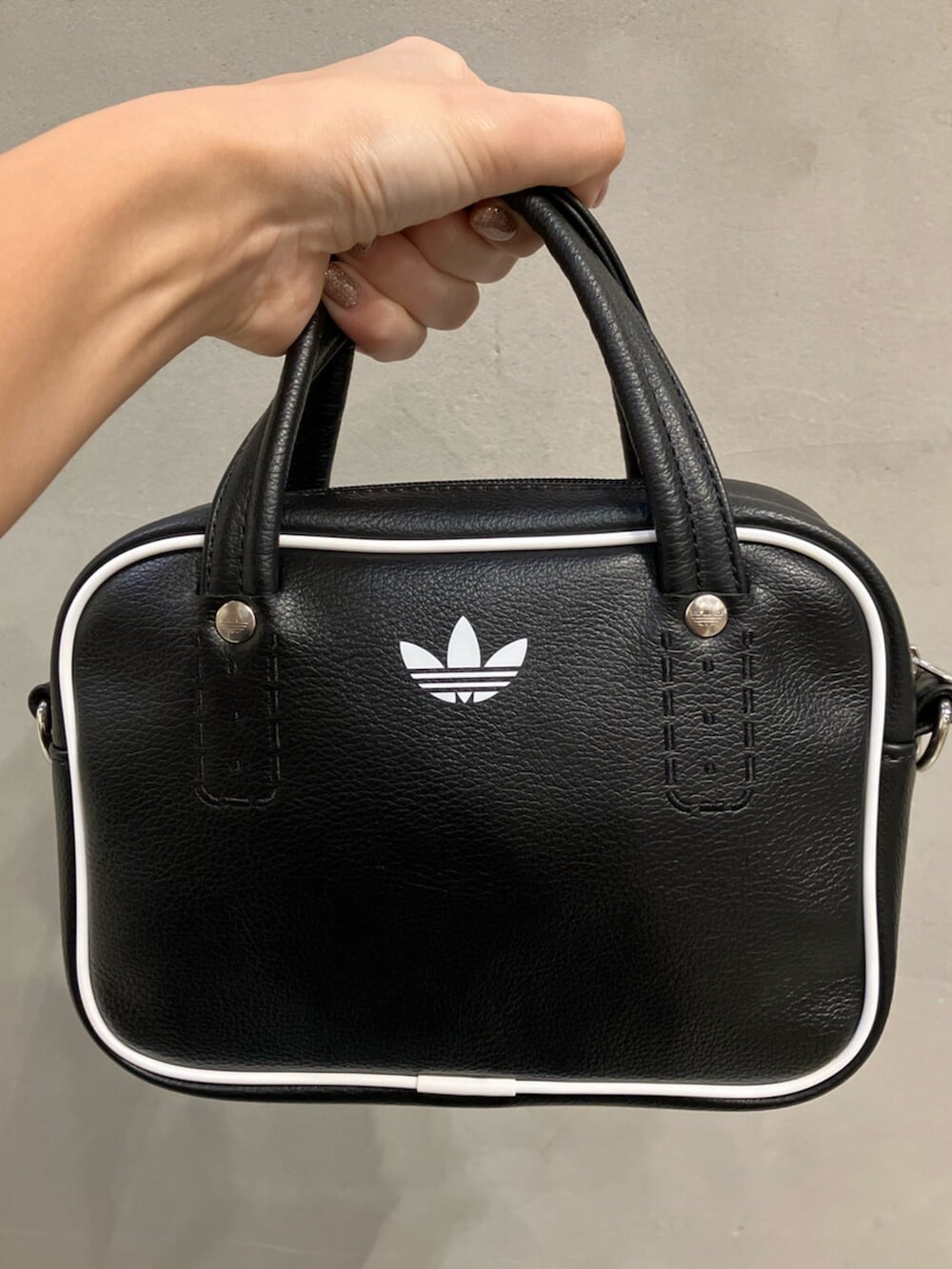 ブラック系のショルダーバッグ、ブラウン系のスニーカー、ブラック系のニット/セーターを着用したレディースの秋コーディネートの4枚目の写真