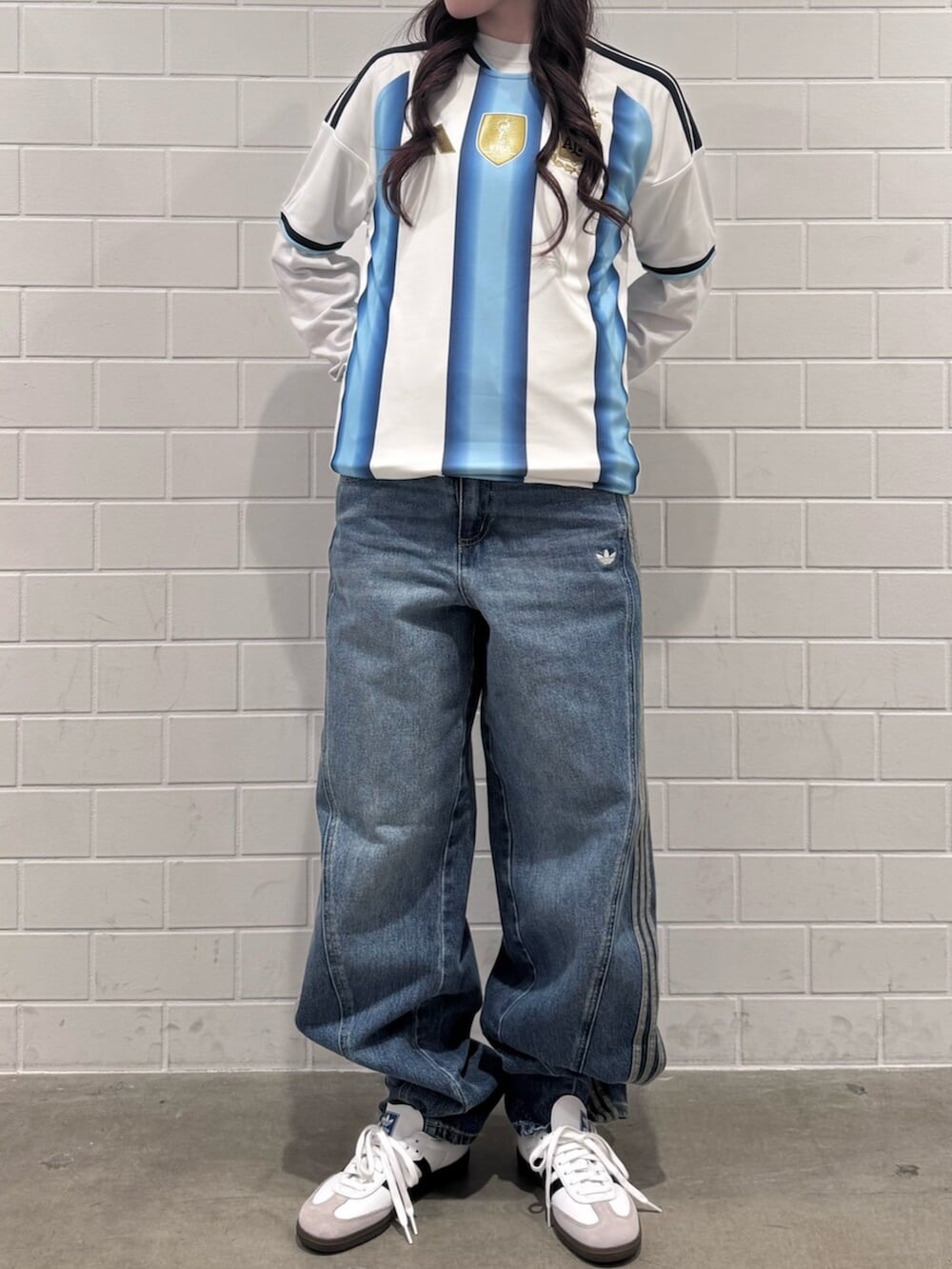 ブルー系のデニムパンツ、ホワイト系のTシャツ/カットソー、ホワイト系のシューズを着用したレディースの秋コーディネートの2枚目の写真