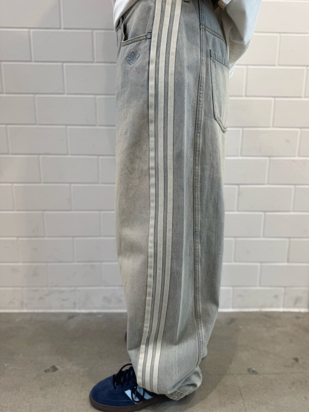 ブルー系のスニーカー、ブルー系のデニムパンツ、ホワイト系のTシャツ/カットソーを着用したレディースの秋コーディネートの5枚目の写真