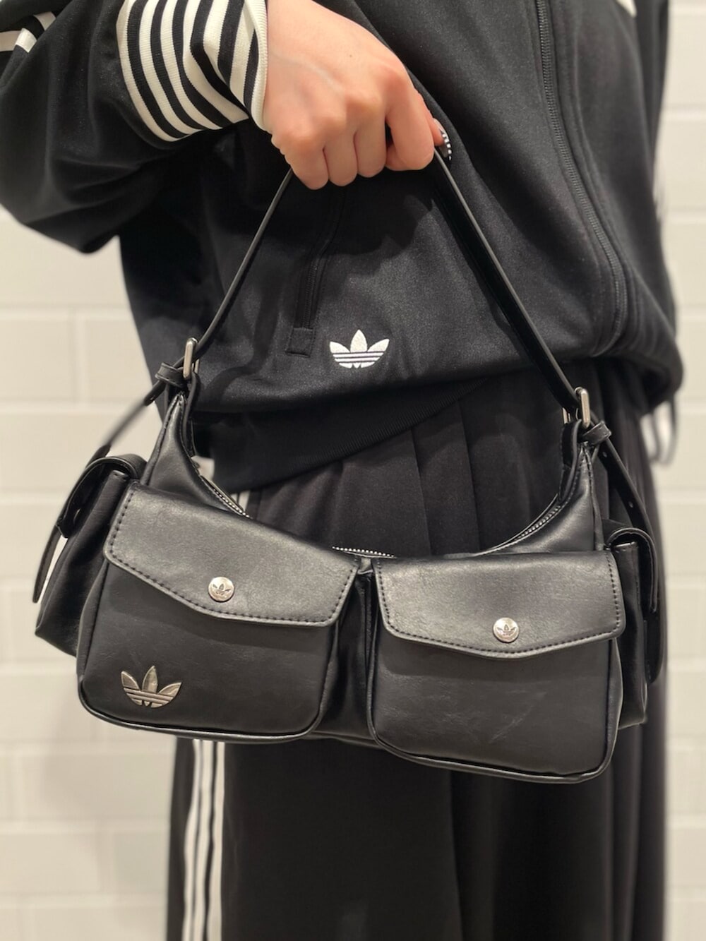 ブラック系のスニーカー、ブラック系のショルダーバッグ、ブラック系のスカートを着用したレディースの冬コーディネートの4枚目の写真