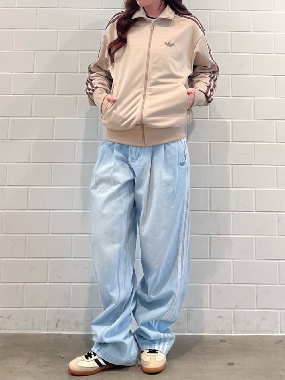 ベージュ系のスニーカー、ブルー系のデニムパンツ、グリーン系のジャージを着用したレディースの春コーディネートの2枚目の写真