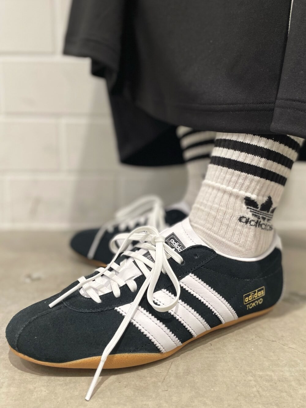 ブラック系のスニーカー、ブラック系のショルダーバッグ、ブラック系のスカートを着用したレディースの冬コーディネートの6枚目の写真