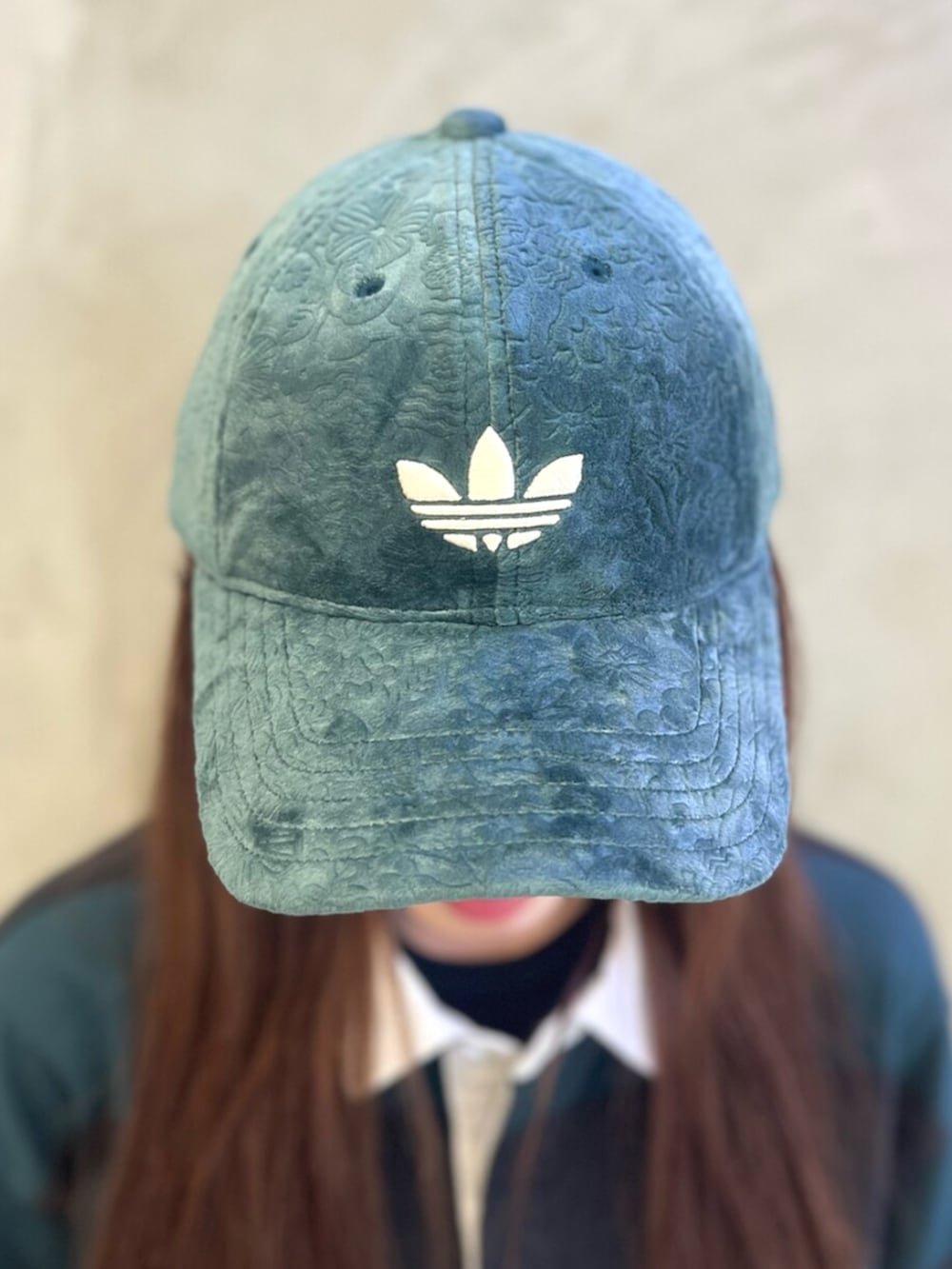 ブラック系のポロシャツ、グリーン系のスニーカー、グリーン系のキャップを着用したレディースの秋コーディネートの3枚目の写真