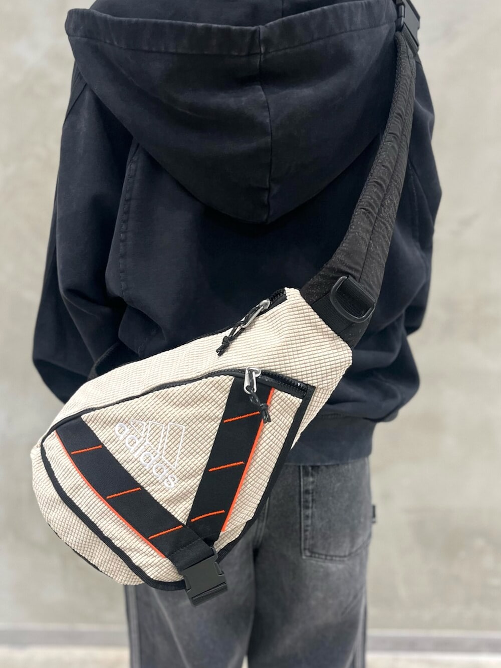 ベージュ系のバックパック/リュック、ブラック系のパーカー、レッド系のTシャツ/カットソーを着用したレディースの夏コーディネートの7枚目の写真