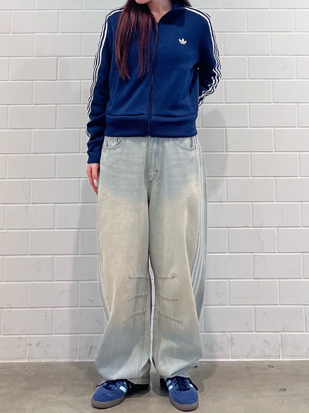 ブルー系のスニーカー、ブルー系のジャージ、ブルー系のデニムパンツを着用したレディースの秋コーディネートの2枚目の写真