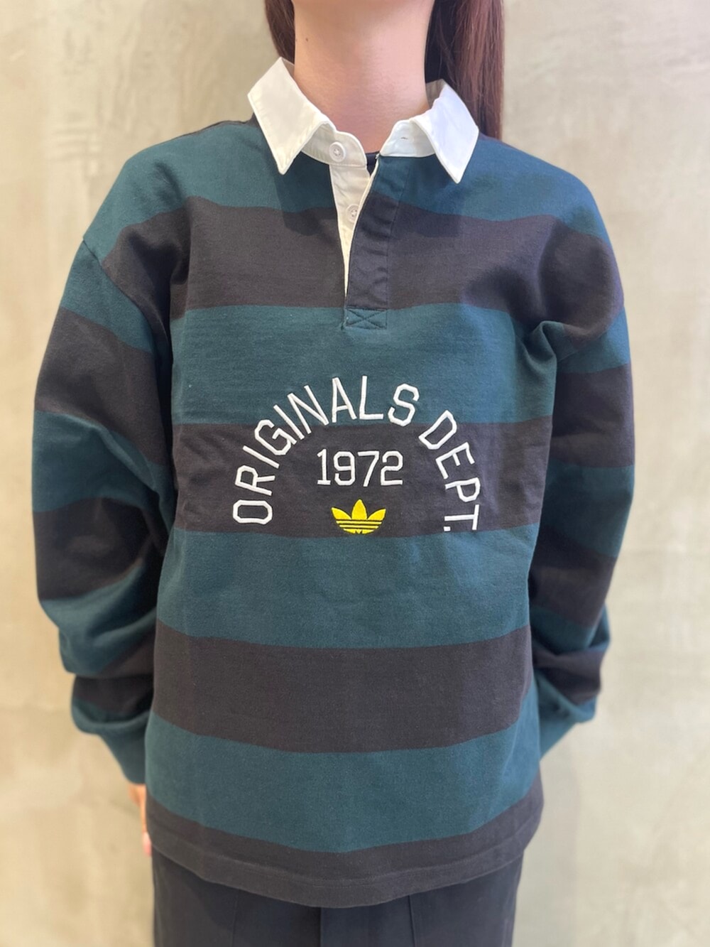 ブラック系のポロシャツ、グリーン系のスニーカー、グリーン系のキャップを着用したレディースの秋コーディネートの4枚目の写真