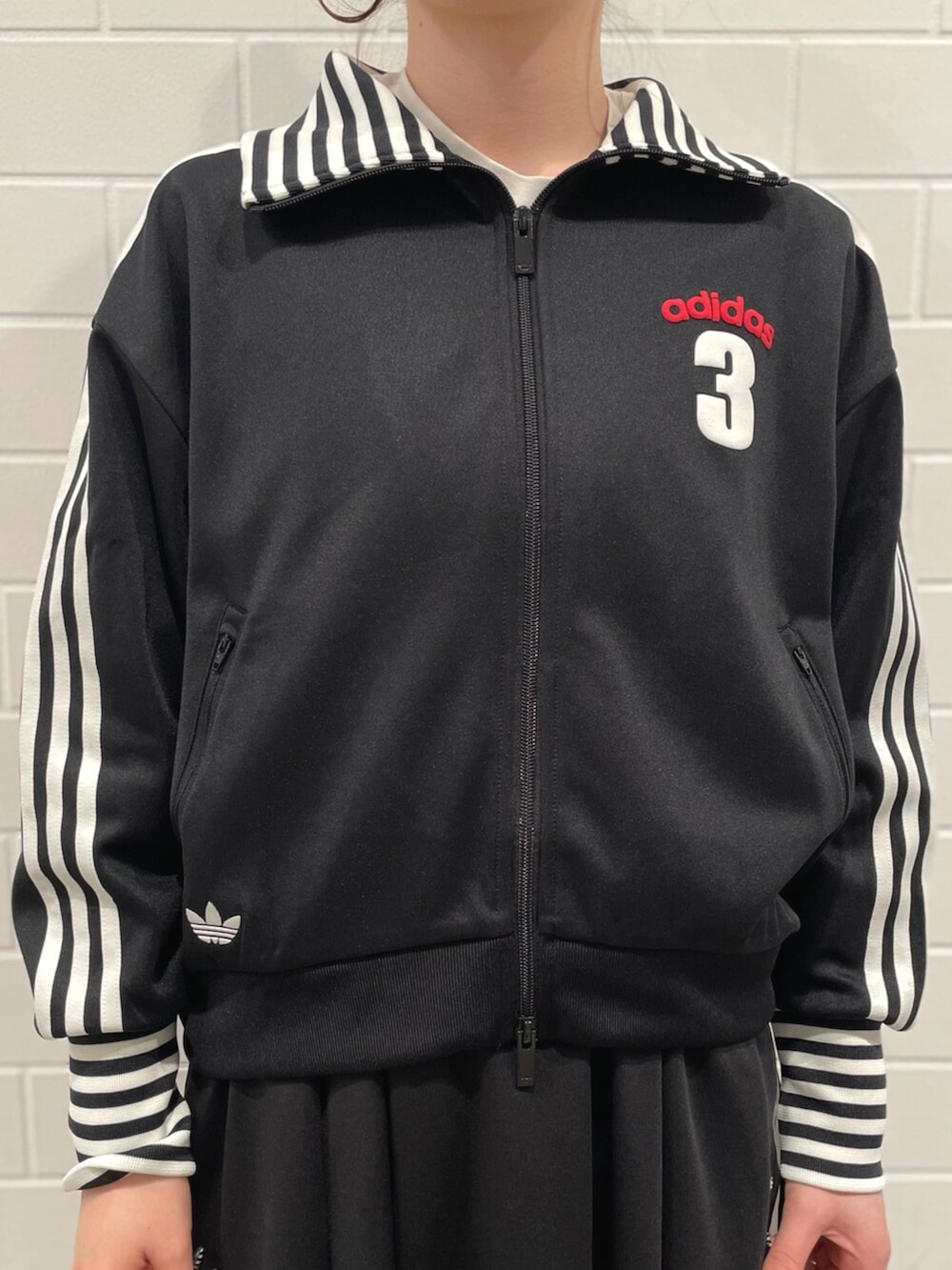 ブラック系のスニーカー、ブラック系のショルダーバッグ、ブラック系のスカートを着用したレディースの冬コーディネートの3枚目の写真