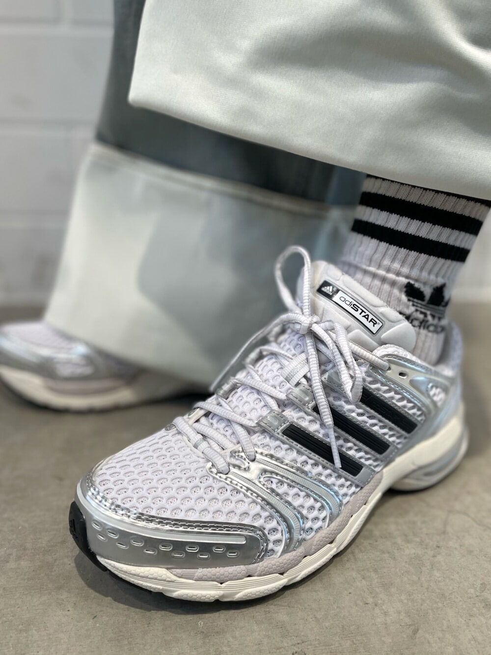 ブラック系のショルダーバッグ、ブルー系のデニムパンツ、グレー系のパーカーを着用したレディースの冬コーディネートの6枚目の写真