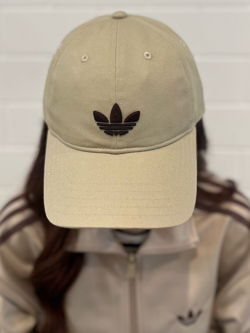 ベージュ系のスニーカー、ブルー系のデニムパンツ、グリーン系のジャージを着用したレディースの春コーディネートの3枚目の写真