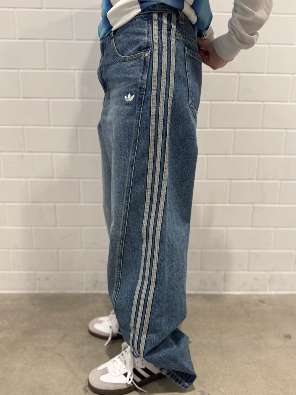 ブルー系のデニムパンツ、ホワイト系のTシャツ/カットソー、ホワイト系のシューズを着用したレディースの秋コーディネートの5枚目の写真