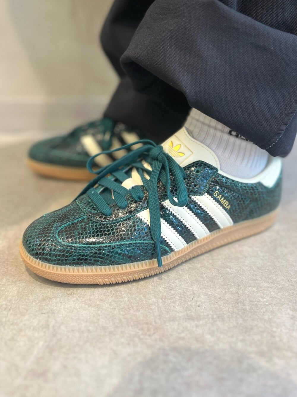 ブラック系のポロシャツ、グリーン系のスニーカー、グリーン系のキャップを着用したレディースの秋コーディネートの6枚目の写真