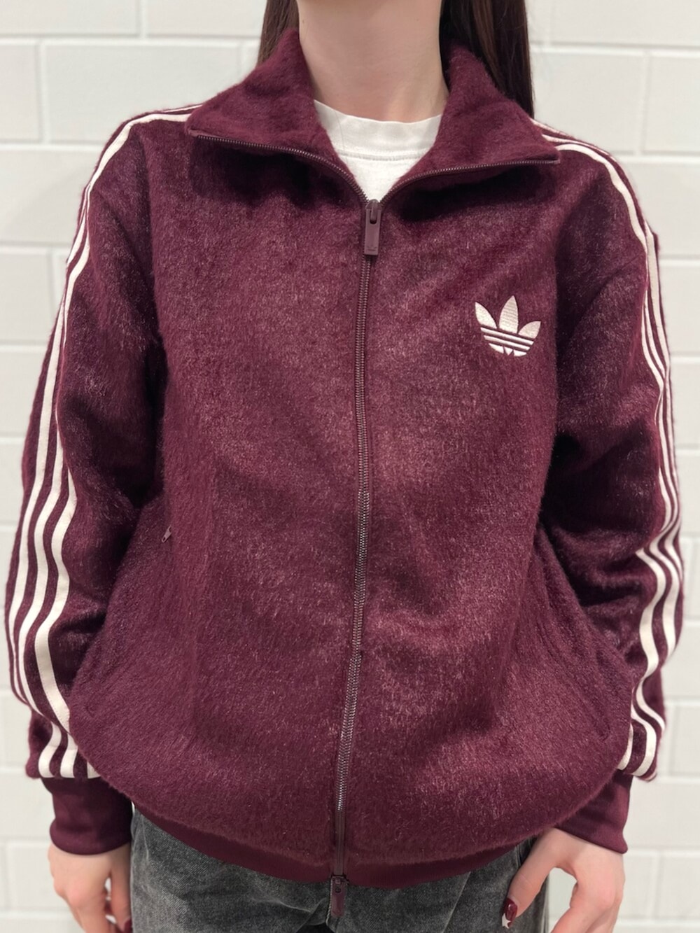 ブラック系のデニムパンツ、ブラウン系のシューズ、レッド系のジャージを着用したレディースの秋コーディネートの4枚目の写真