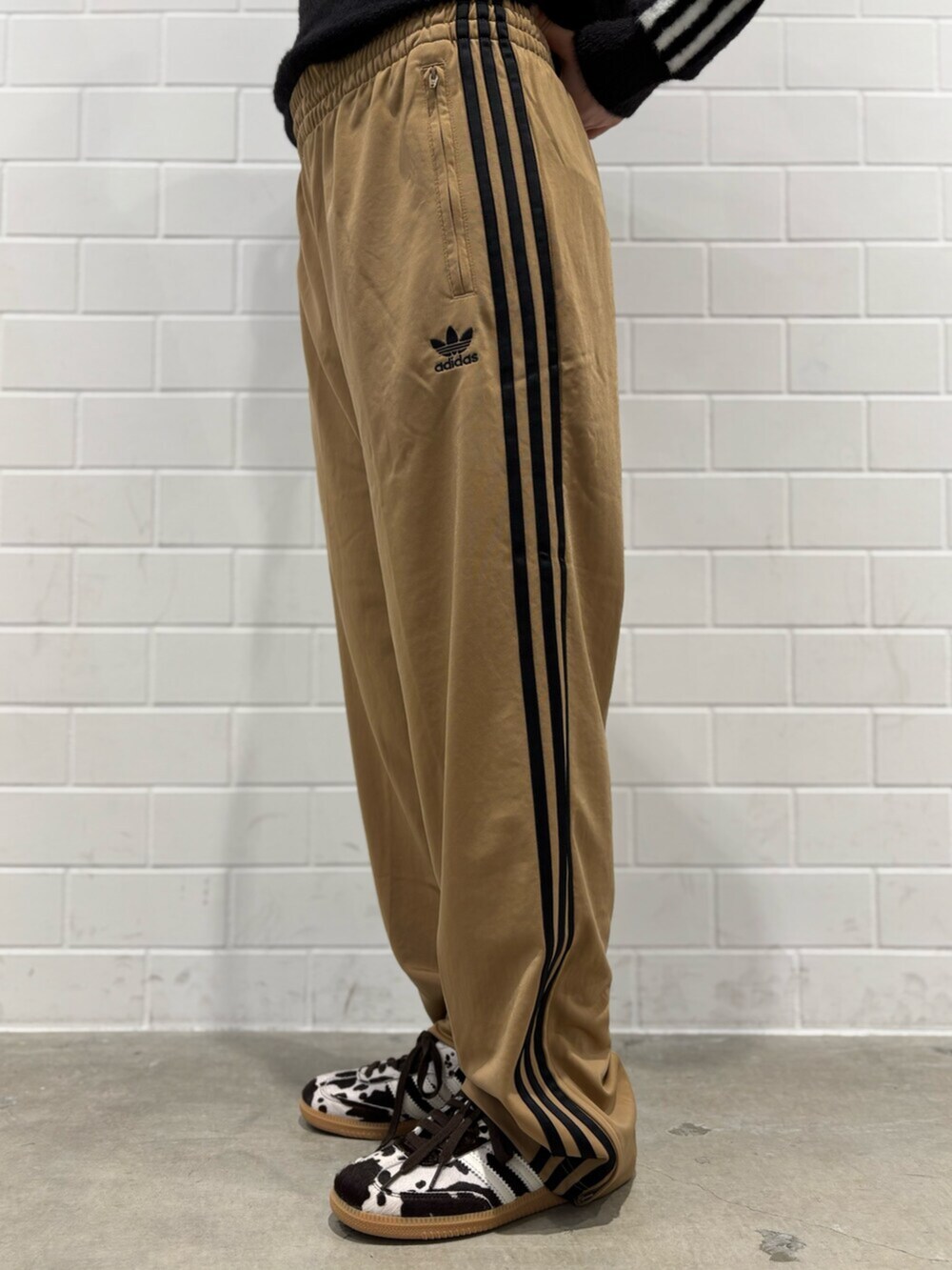 ブラック系のショルダーバッグ、ブラウン系のスニーカー、ブラック系のニット/セーターを着用したレディースの秋コーディネートの5枚目の写真