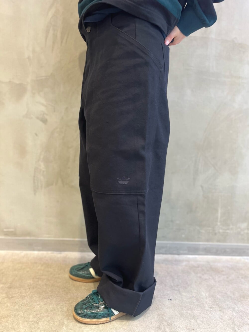 ブラック系のポロシャツ、グリーン系のスニーカー、グリーン系のキャップを着用したレディースの秋コーディネートの5枚目の写真