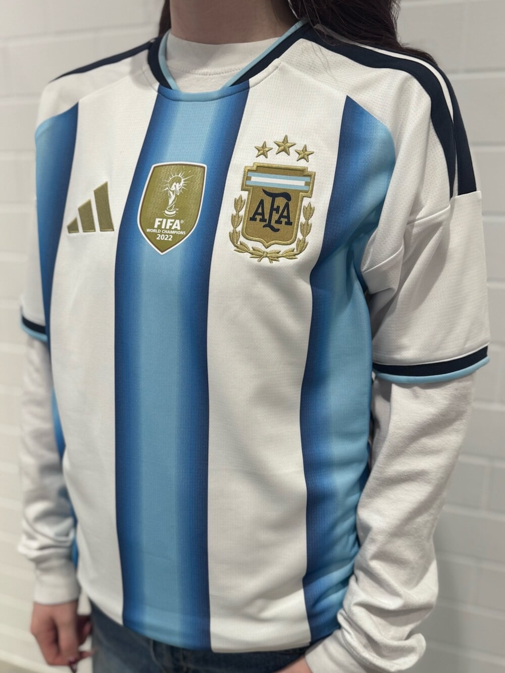 ブルー系のデニムパンツ、ホワイト系のTシャツ/カットソー、ホワイト系のシューズを着用したレディースの秋コーディネートの4枚目の写真