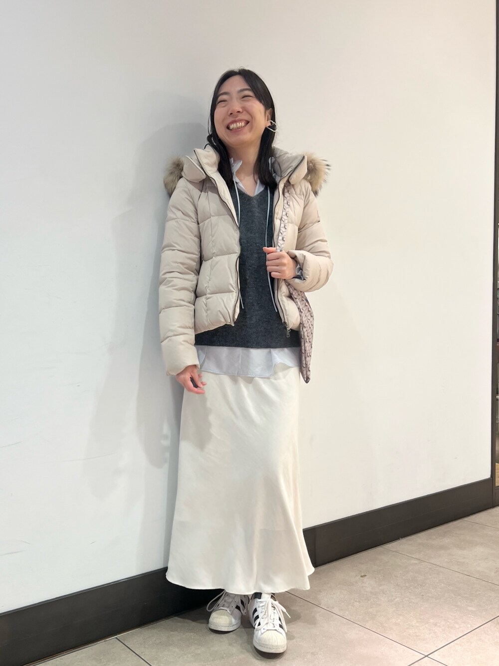 グレー系のニット/セーター、ブルー系のシャツ/ブラウス、ブルー系のショルダーバッグを着用したレディースの冬コーディネートの10枚目の写真