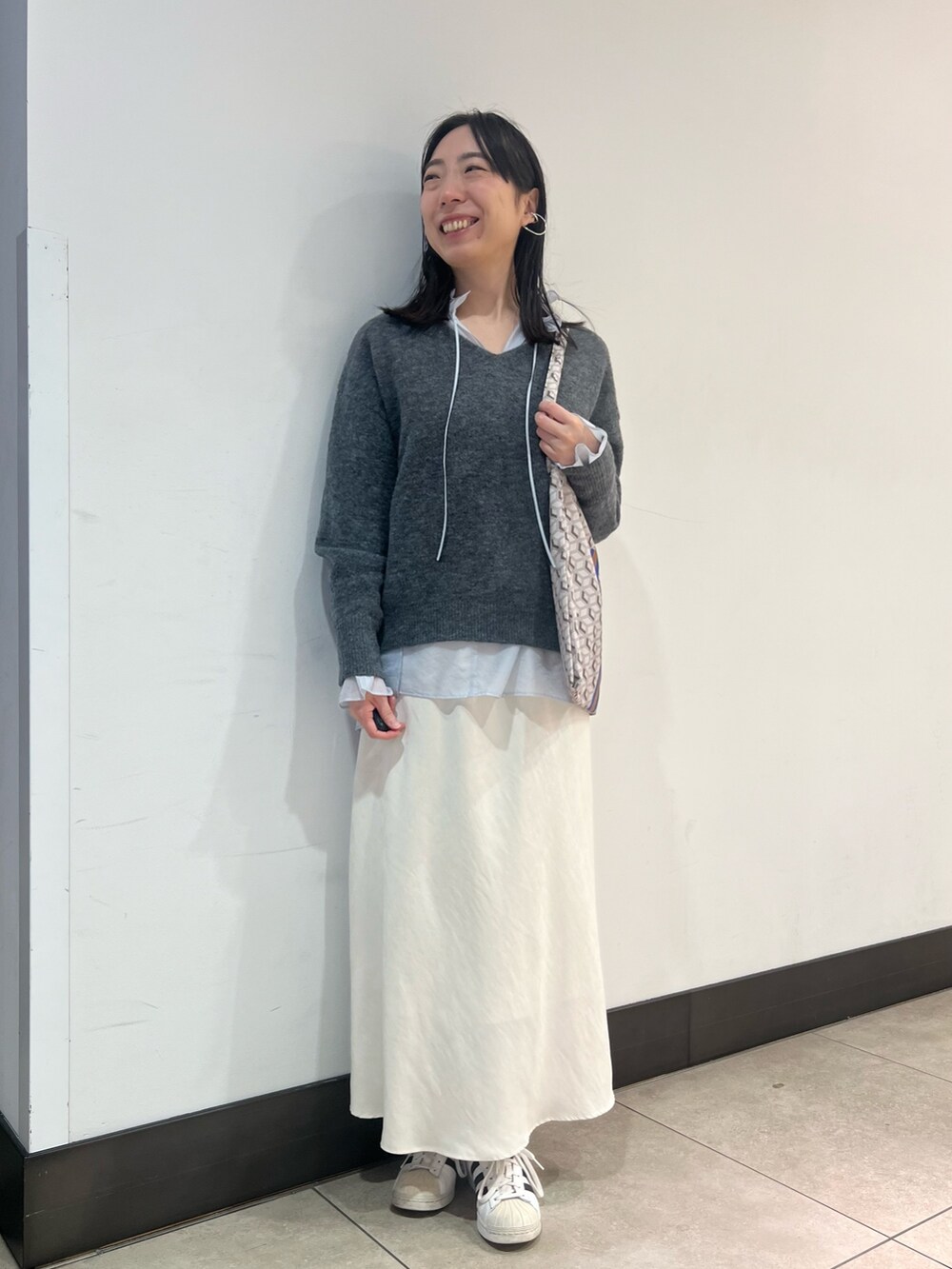 グレー系のニット/セーター、ブルー系のシャツ/ブラウス、ブルー系のショルダーバッグを着用したレディースの冬コーディネートの8枚目の写真