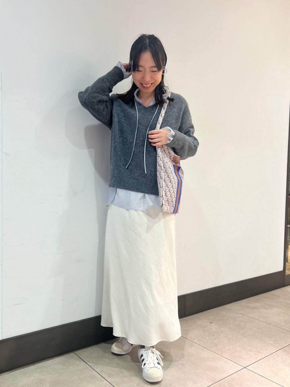 グレー系のニット/セーター、ブルー系のシャツ/ブラウス、ブルー系のショルダーバッグを着用したレディースの冬コーディネートの4枚目の写真