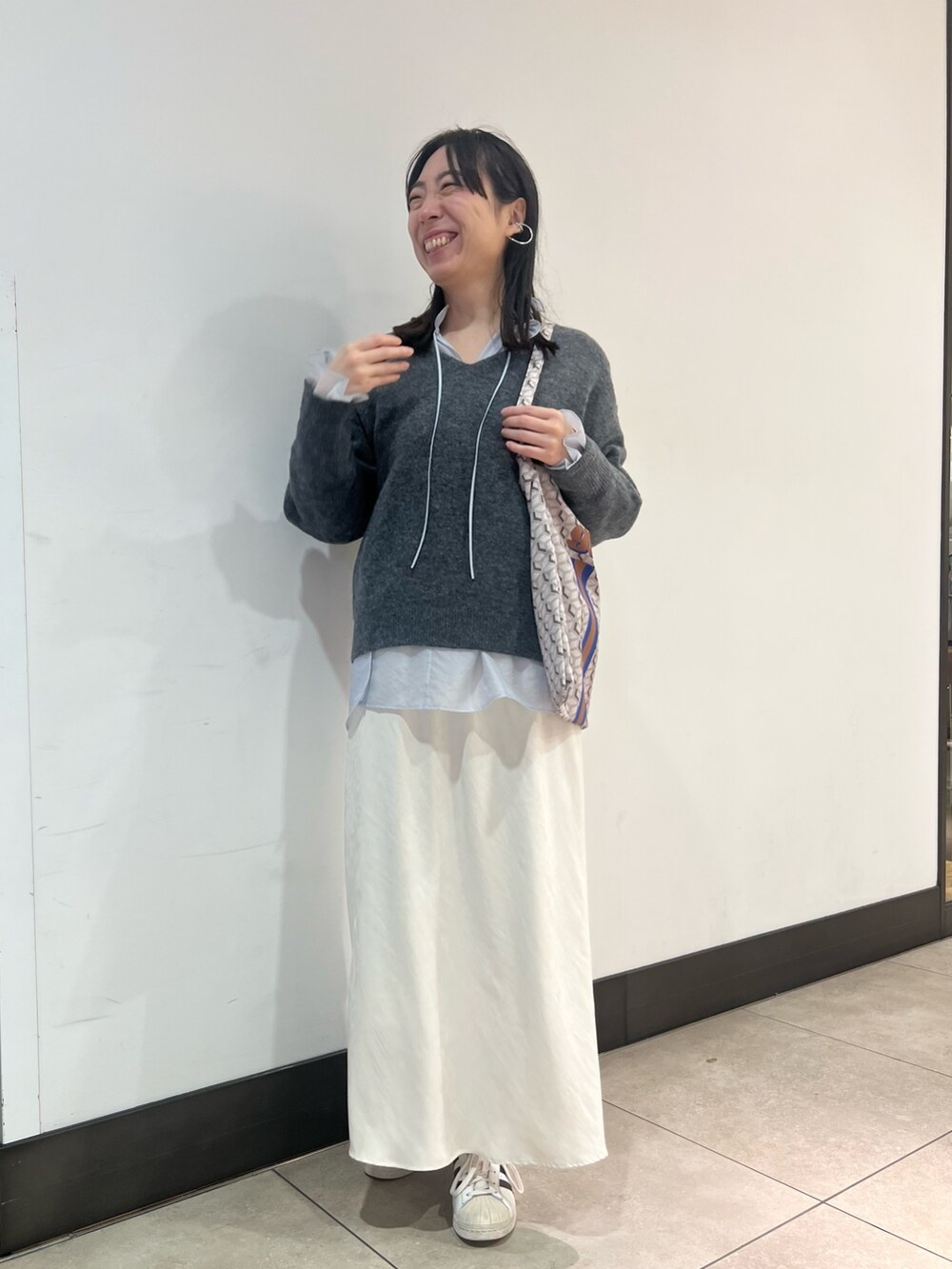 グレー系のニット/セーター、ブルー系のシャツ/ブラウス、ブルー系のショルダーバッグを着用したレディースの冬コーディネートの3枚目の写真