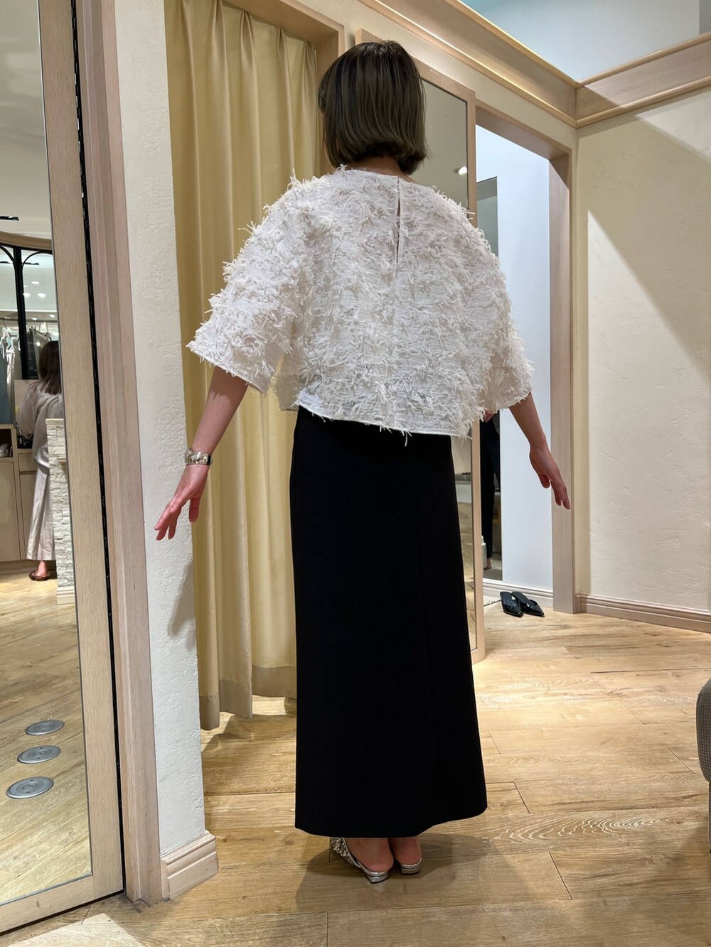 ホワイト系のシャツ/ブラウス、ブラック系のスカートを着用したレディースの春コーディネートの3枚目の写真