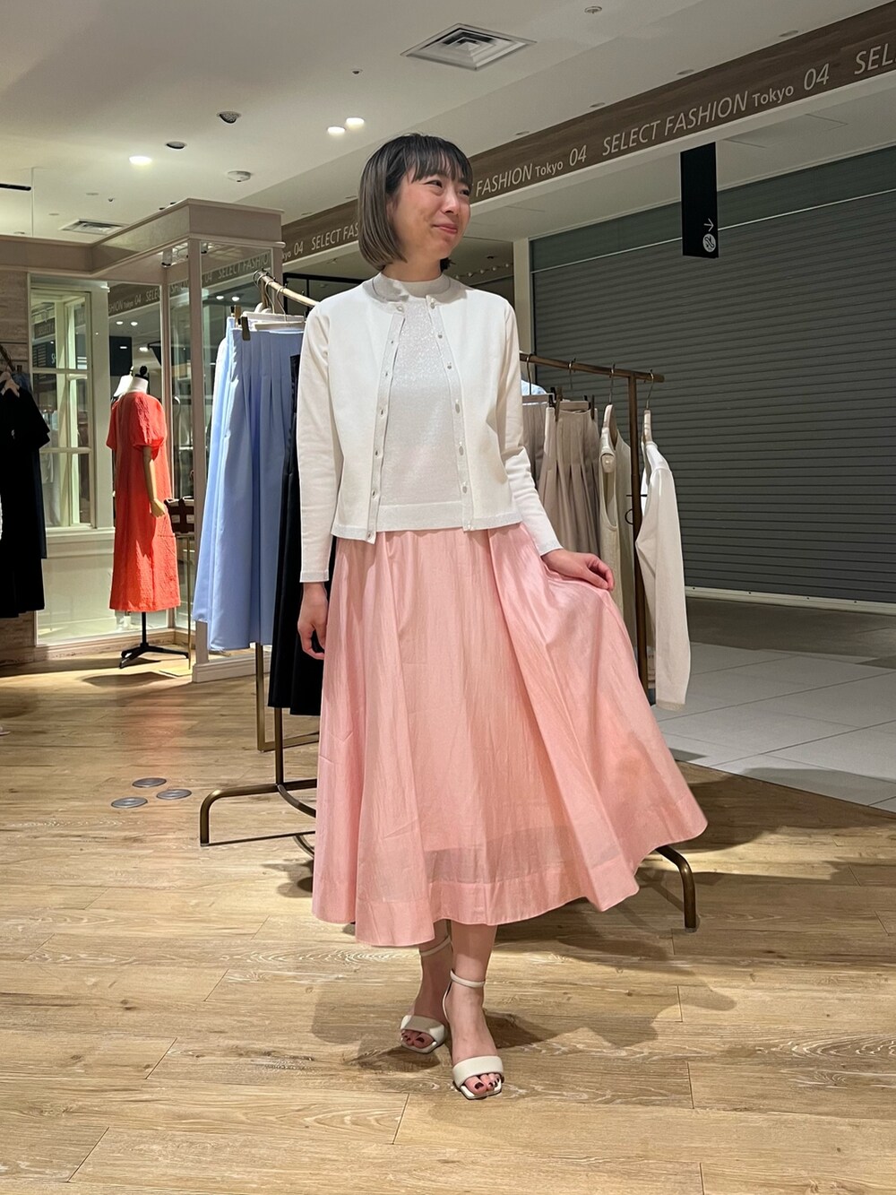 シルバー系のカーディガン/ボレロ、シルバー系のニット/セーター、ピンク系のスカートを着用したレディースの春コーディネートの2枚目の写真