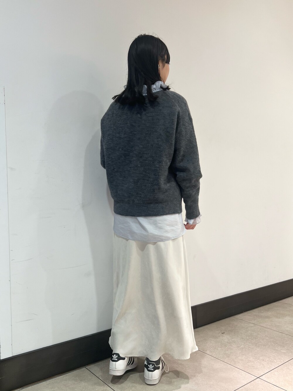 グレー系のニット/セーター、ブルー系のシャツ/ブラウス、ブルー系のショルダーバッグを着用したレディースの冬コーディネートの6枚目の写真