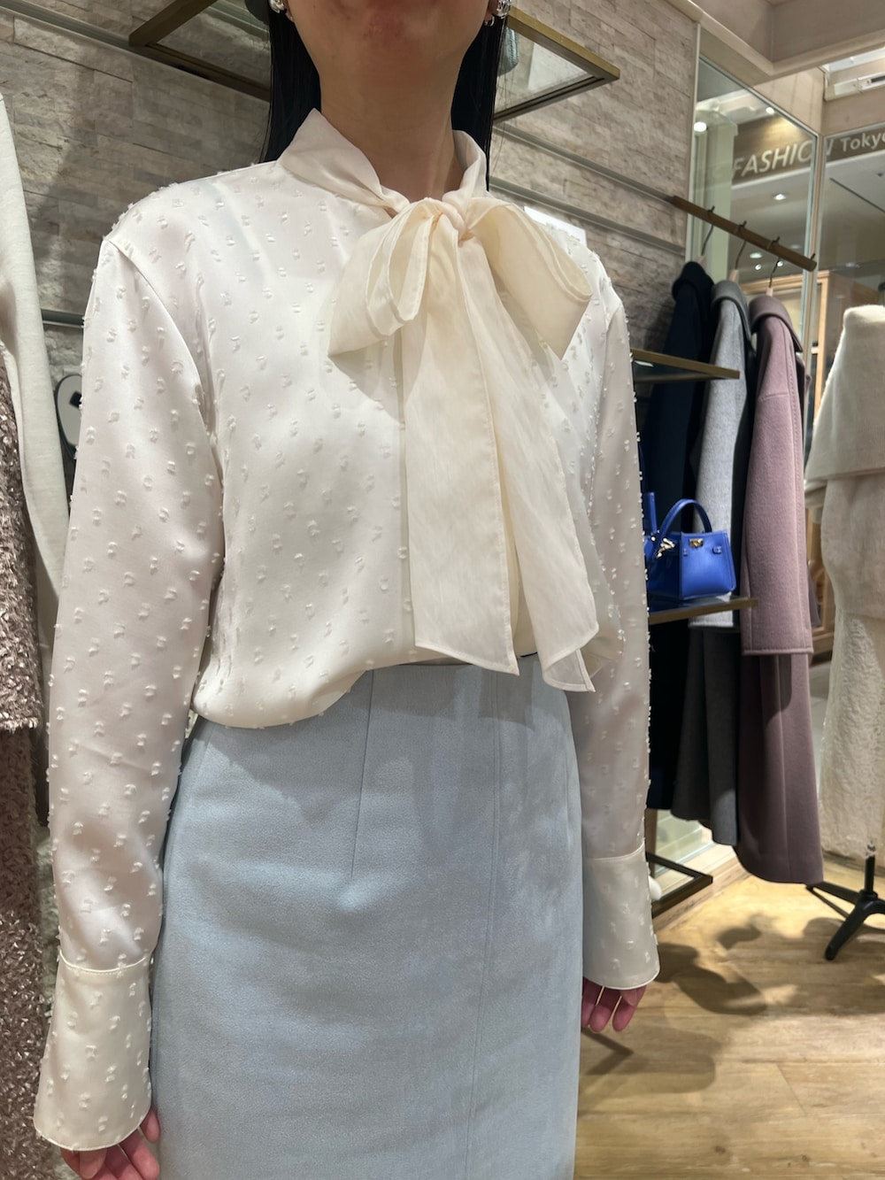 グリーン系のスカート、グレー系のその他アウター、ホワイト系のシャツ/ブラウスを着用したレディースの秋コーディネートの3枚目の写真