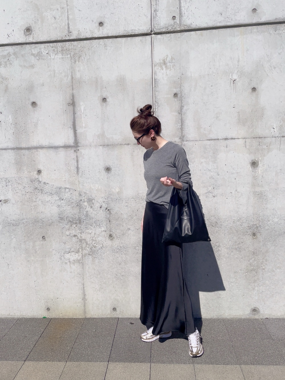 ホワイト系のスニーカー、ブラック系のハンドバッグ、グレー系のTシャツ/カットソーを着用したレディースの秋コーディネートの2枚目の写真