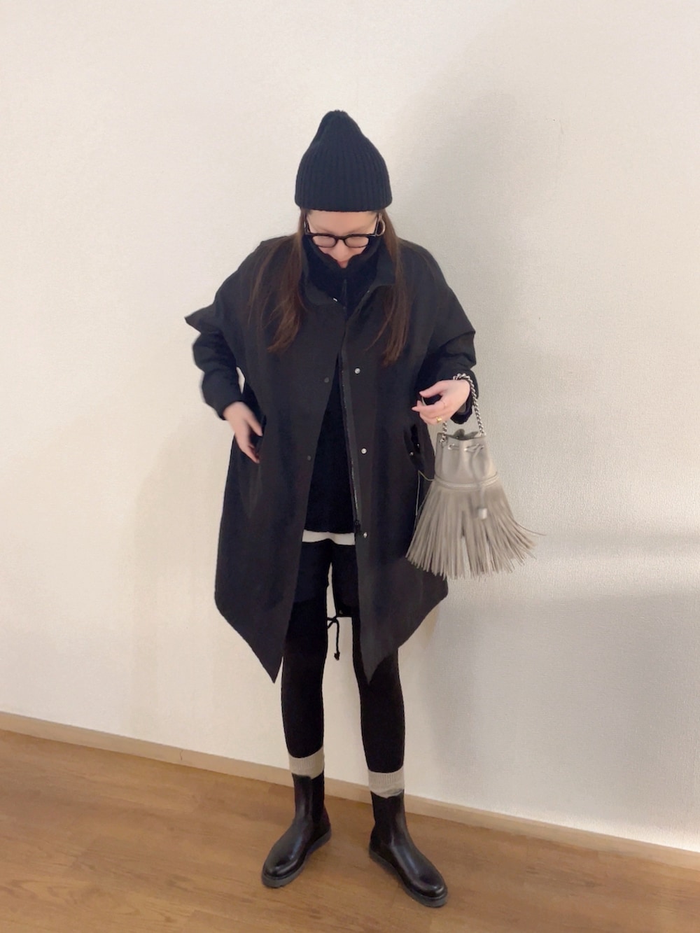 ベージュ系のショルダーバッグ、ブラック系のトップス、ブラック系のジャケット/アウターを着用したレディースの冬コーディネートの2枚目の写真