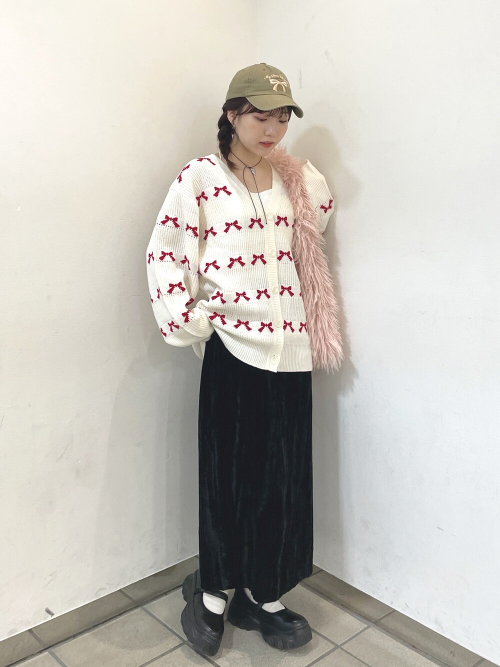 ホワイト系のカーディガン/ボレロ、ピンク系のトートバッグ、ブラック系のスカートを着用したレディースの秋コーディネートの3枚目の写真