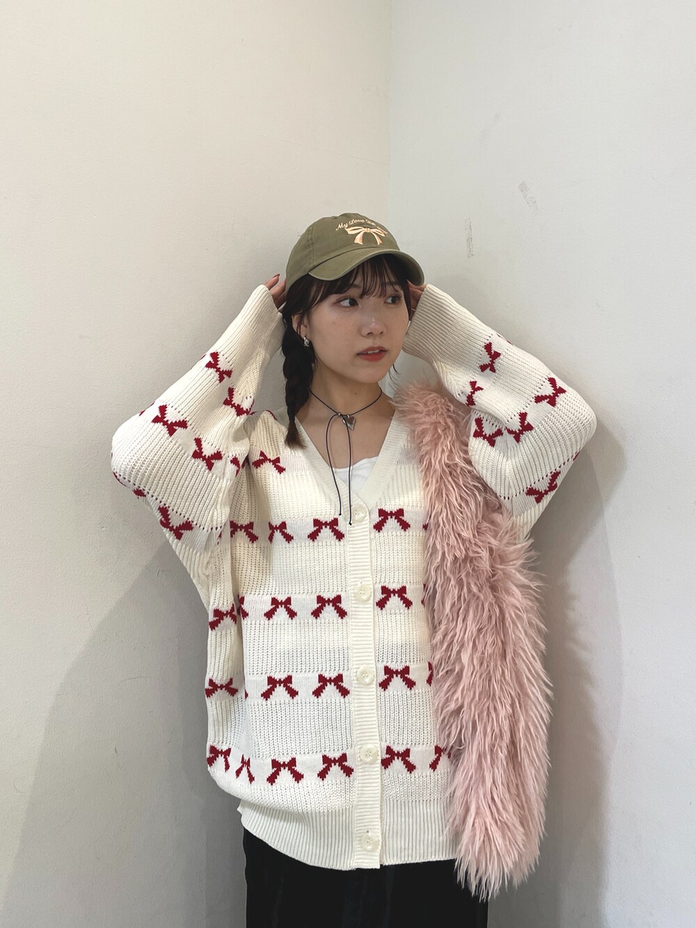 ホワイト系のカーディガン/ボレロ、ピンク系のトートバッグ、ブラック系のスカートを着用したレディースの秋コーディネートの2枚目の写真