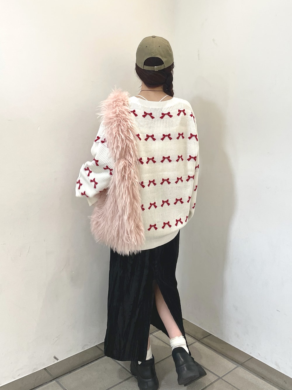 ホワイト系のカーディガン/ボレロ、ピンク系のトートバッグ、ブラック系のスカートを着用したレディースの秋コーディネートの4枚目の写真