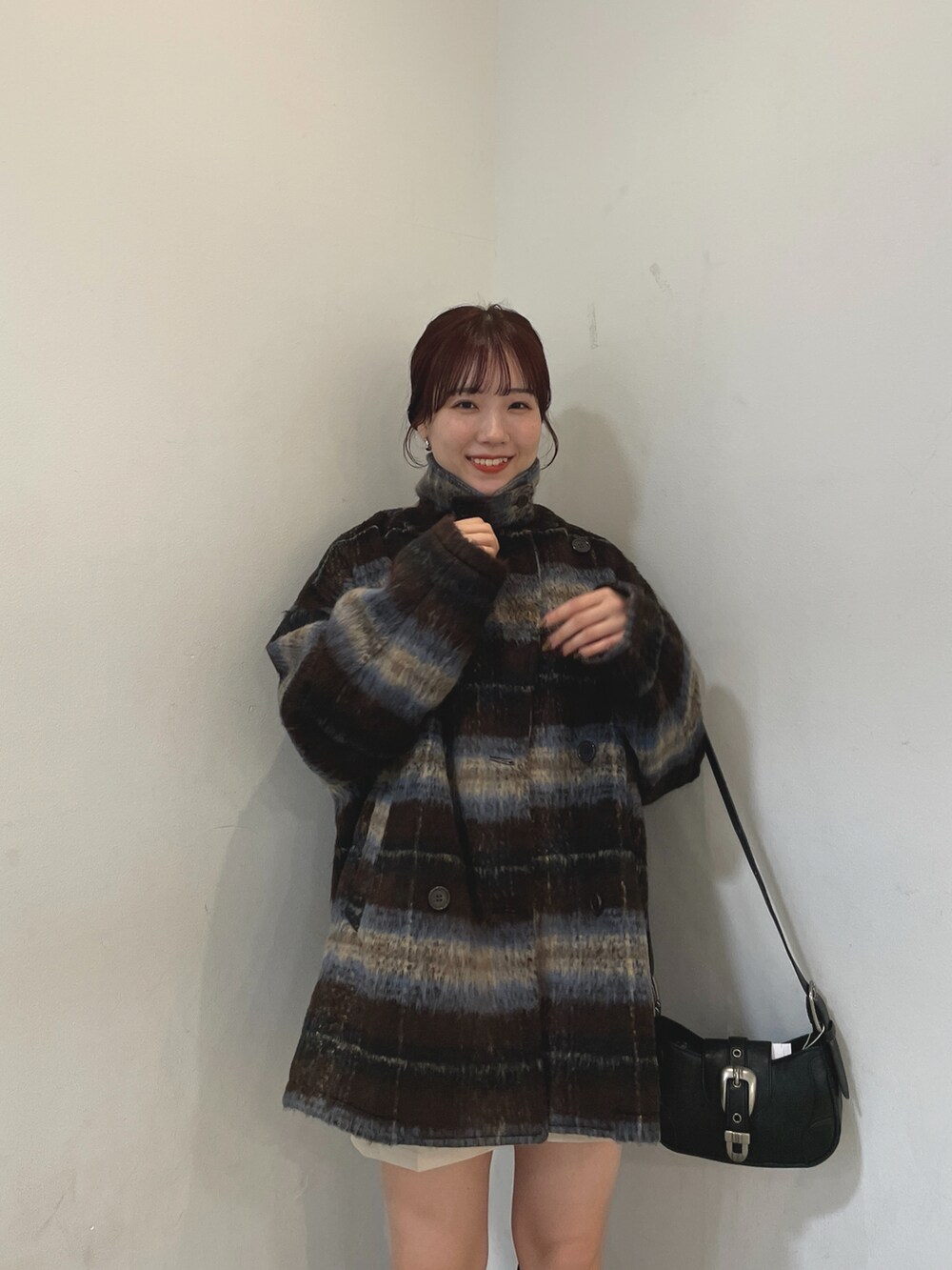 ブルー系のニット/セーター、ブラウン系のその他アウター、ブラック系のブーツを着用したレディースの冬コーディネートの4枚目の写真