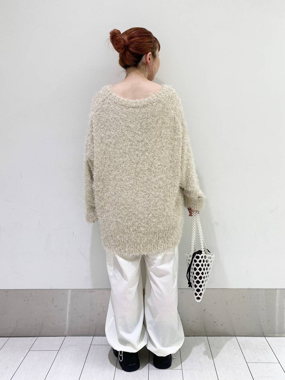 ブラック系のタンクトップ、ブラック系のブーツ、ホワイト系のその他パンツを着用したレディースの秋コーディネートの2枚目の写真