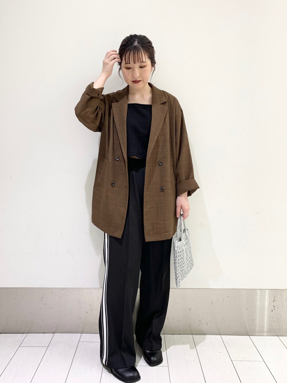 シルバー系のショルダーバッグ、ブラック系のその他パンツ、ブラック系のパンプスを着用したレディースの春コーディネートの2枚目の写真