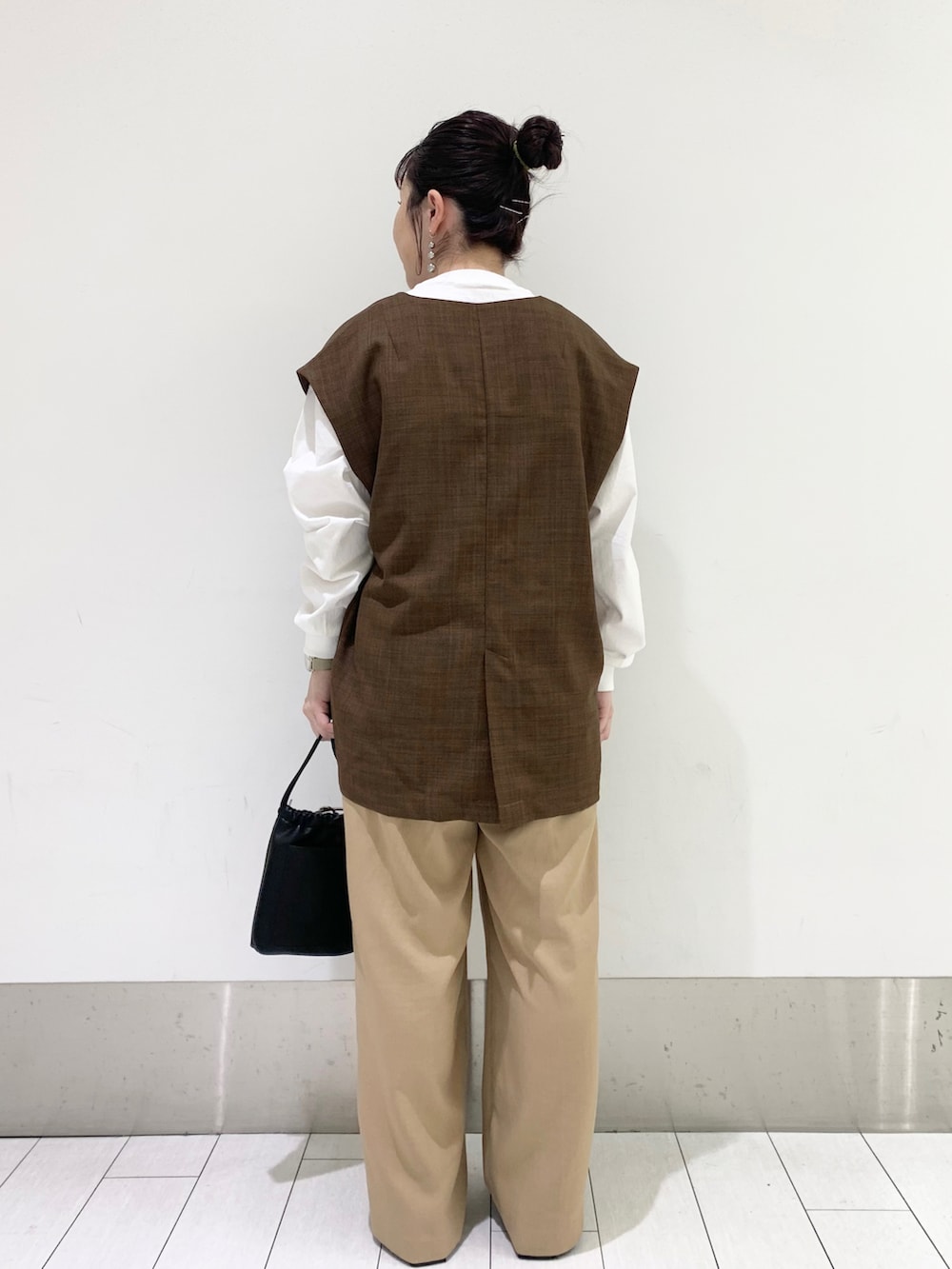 ブラック系のショルダーバッグ、ブラック系のパンプス、ベージュ系のその他パンツを着用したレディースの春コーディネートの2枚目の写真