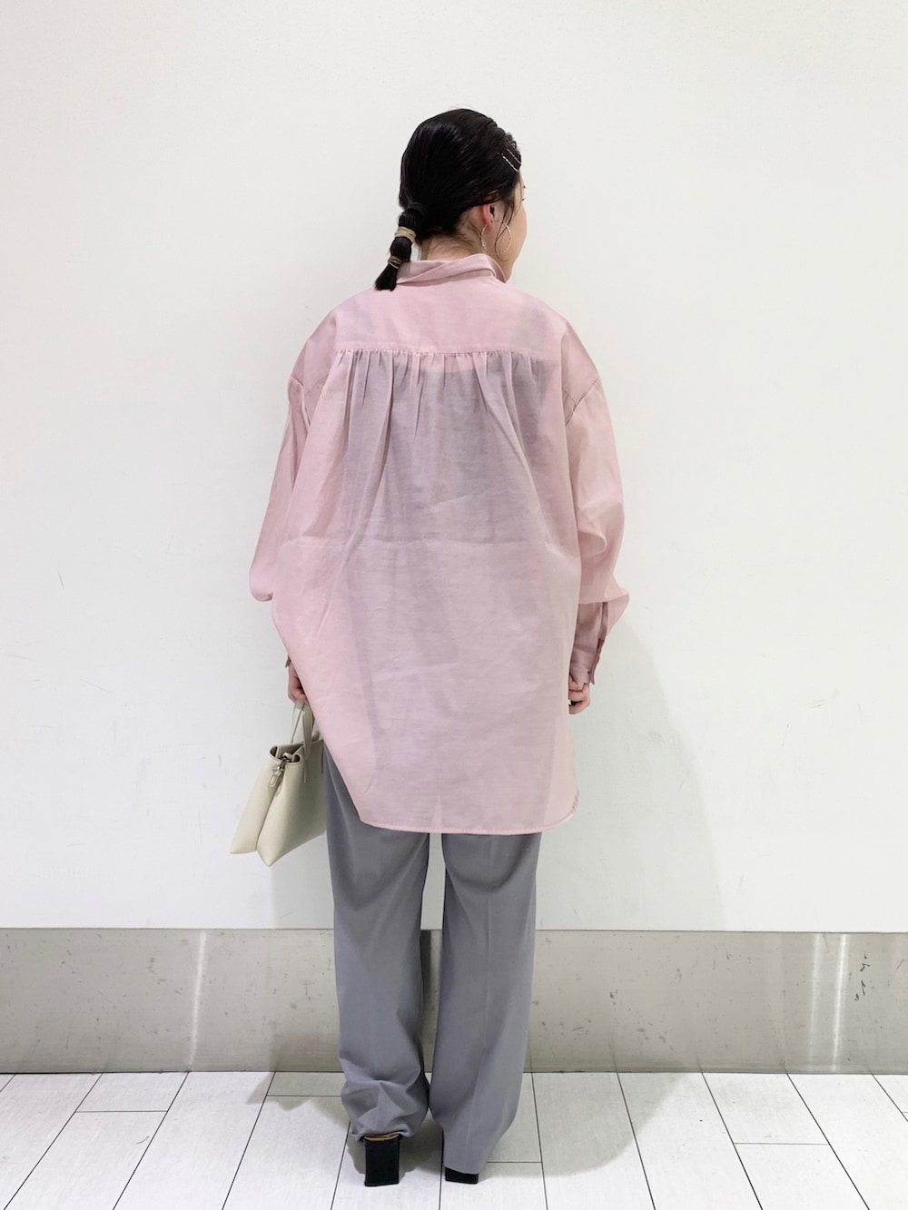 ブラック系のパンプス、グレー系のその他パンツ、ホワイト系のショルダーバッグを着用したレディースの春コーディネートの2枚目の写真