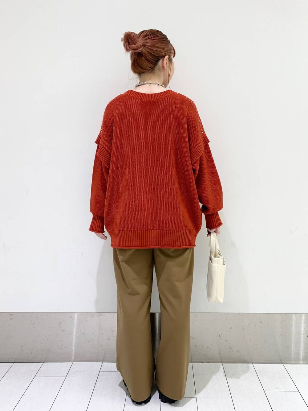 レッド系のTシャツ/カットソー、ホワイト系のショルダーバッグ、ベージュ系のその他パンツを着用したレディースの秋コーディネートの2枚目の写真