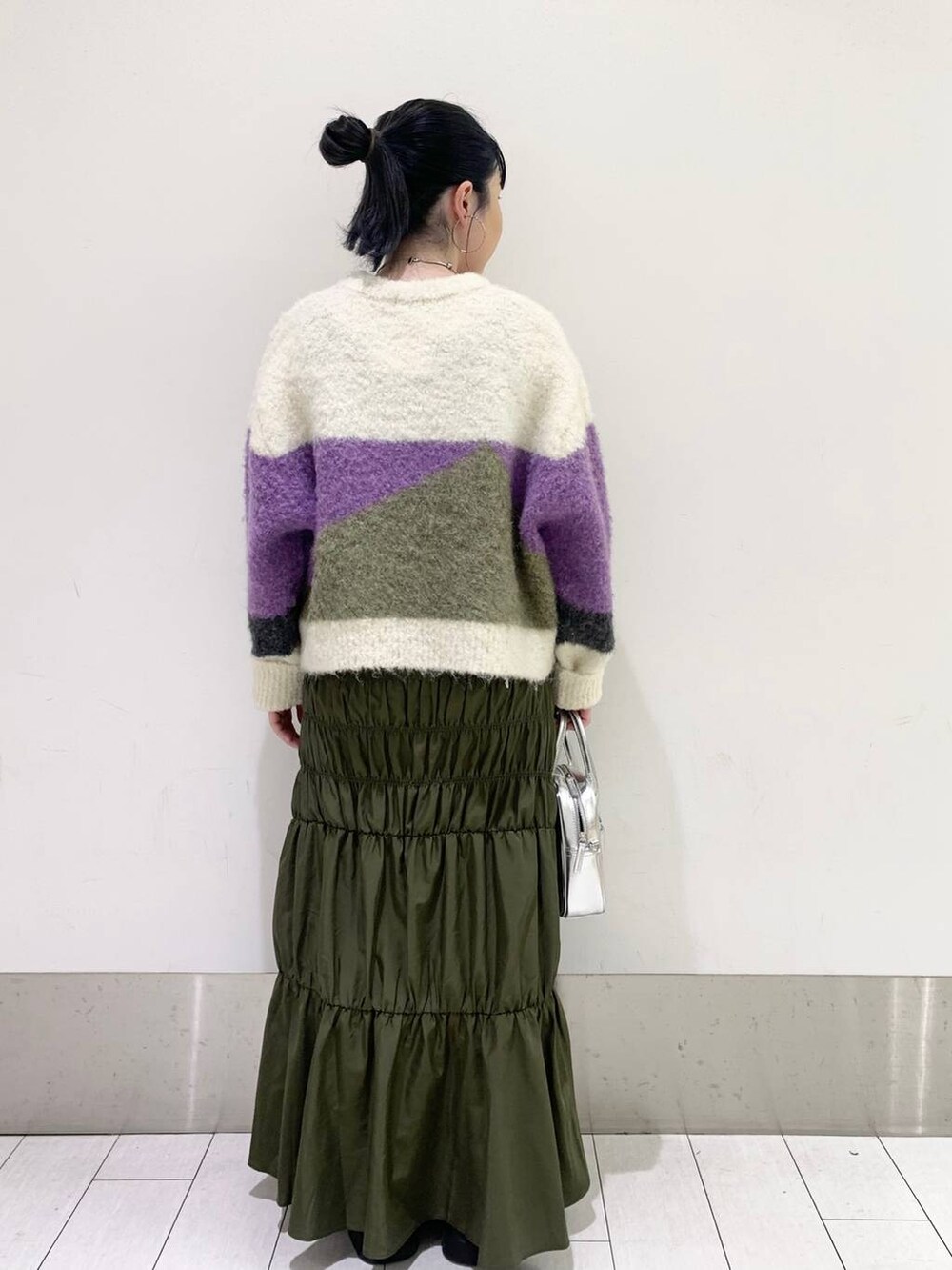 ブラック系のブーツ、パープル系のニット/セーター、シルバー系のボストンバッグを着用したレディースの秋コーディネートの2枚目の写真