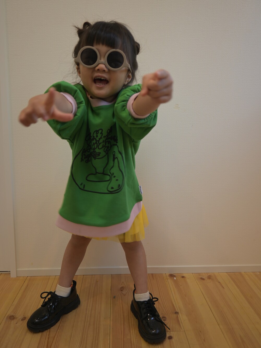 グリーン系のパーカー、イエロー系のスウェット、ブラック系のシューズを着用したキッズの秋コーディネートの4枚目の写真