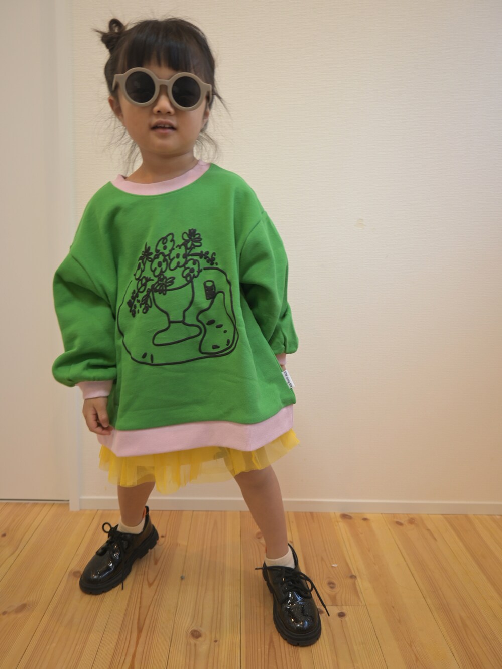 グリーン系のパーカー、イエロー系のスウェット、ブラック系のシューズを着用したキッズの秋コーディネートの3枚目の写真