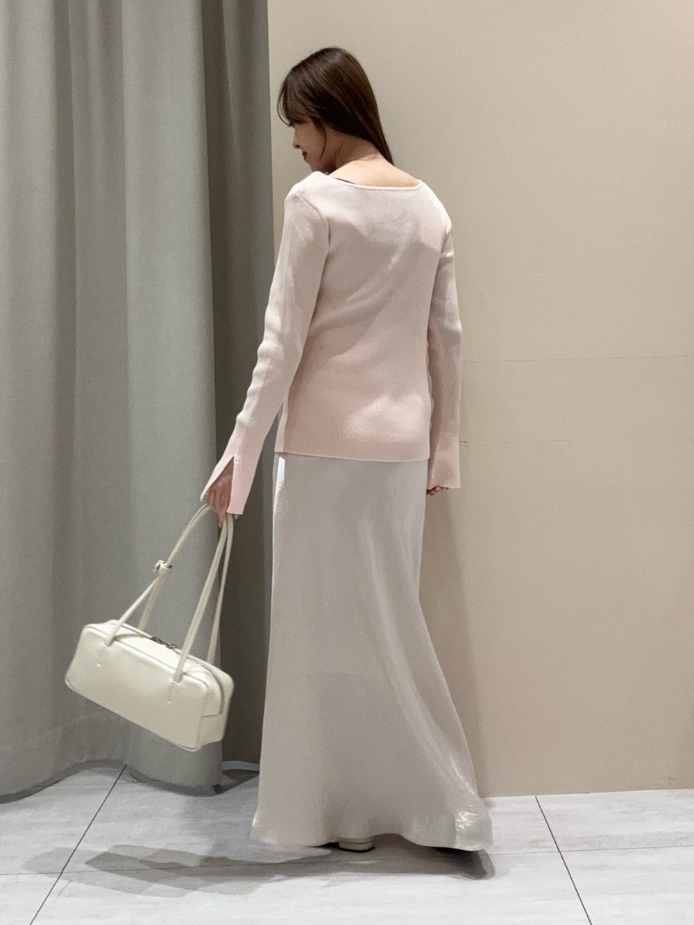 ピンク系のニット/セーター、ホワイト系のスカートを着用したレディースの春コーディネートの3枚目の写真