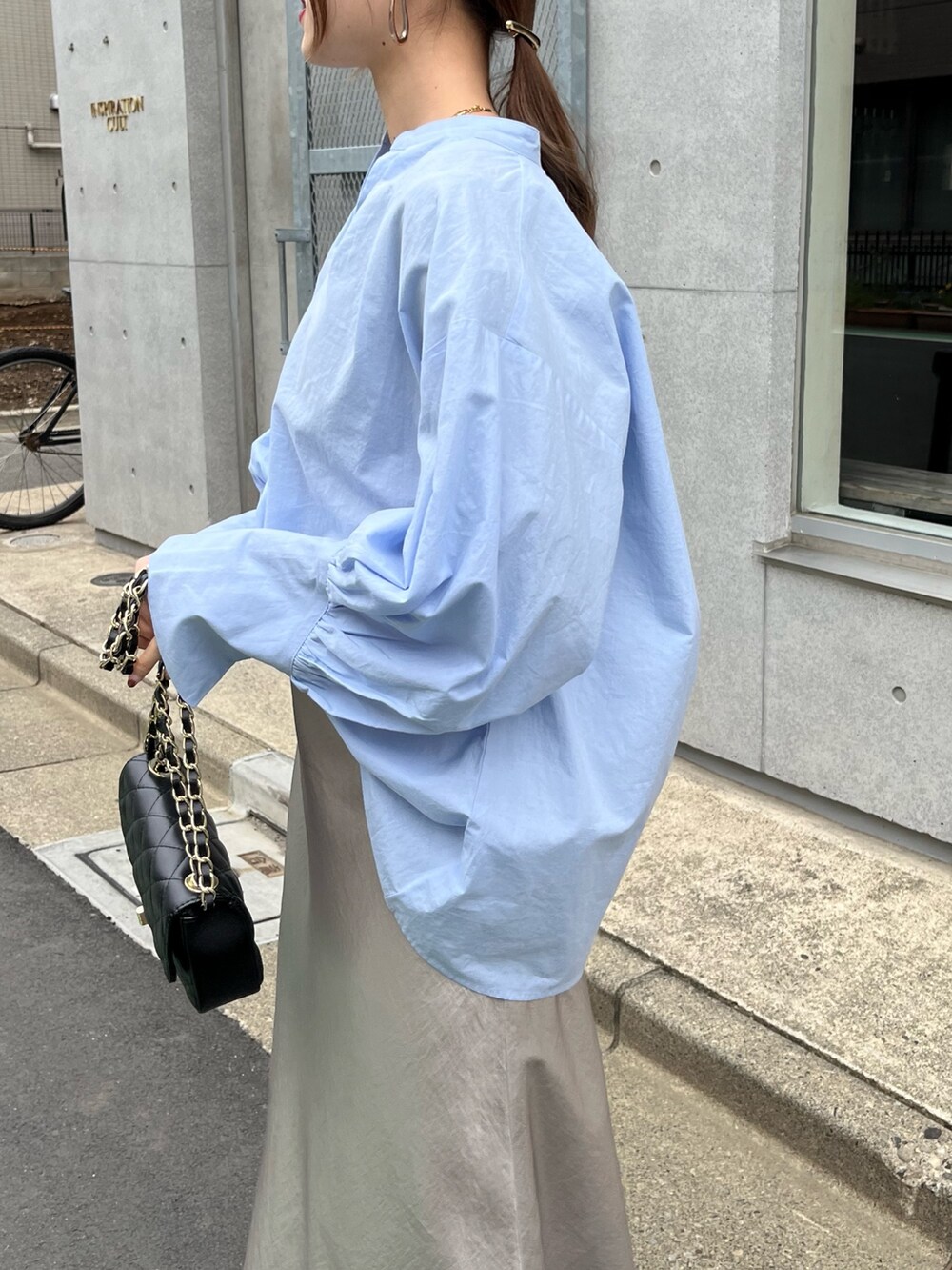 ブルー系のシャツ/ブラウス、ブラック系のショルダーバッグ、ベージュ系のスカートを着用したレディースの春コーディネートの5枚目の写真