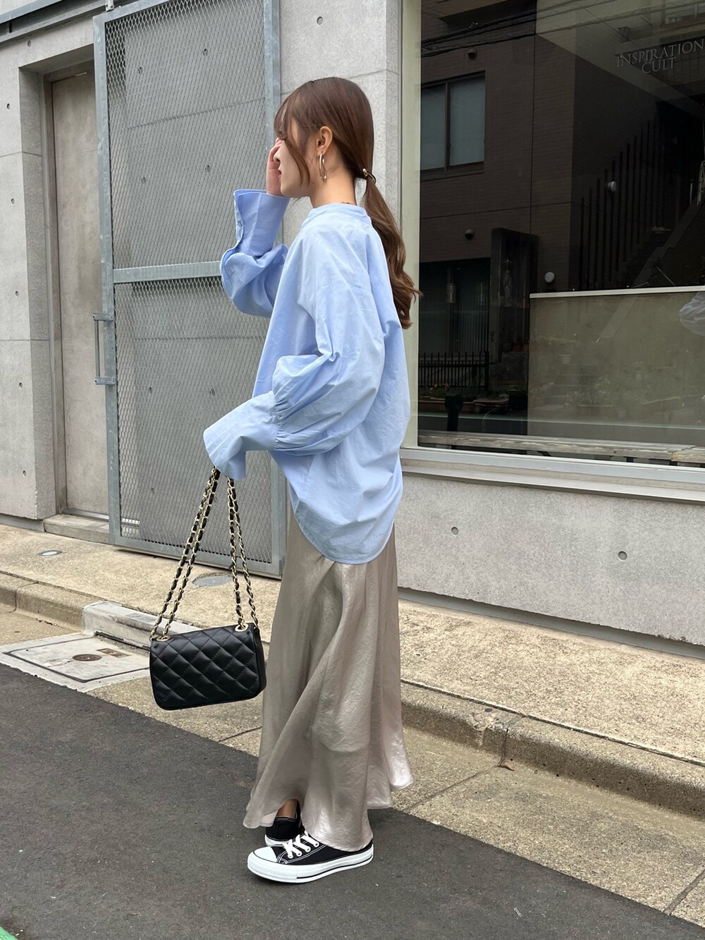 ブルー系のシャツ/ブラウス、ブラック系のショルダーバッグ、ベージュ系のスカートを着用したレディースの春コーディネートの3枚目の写真